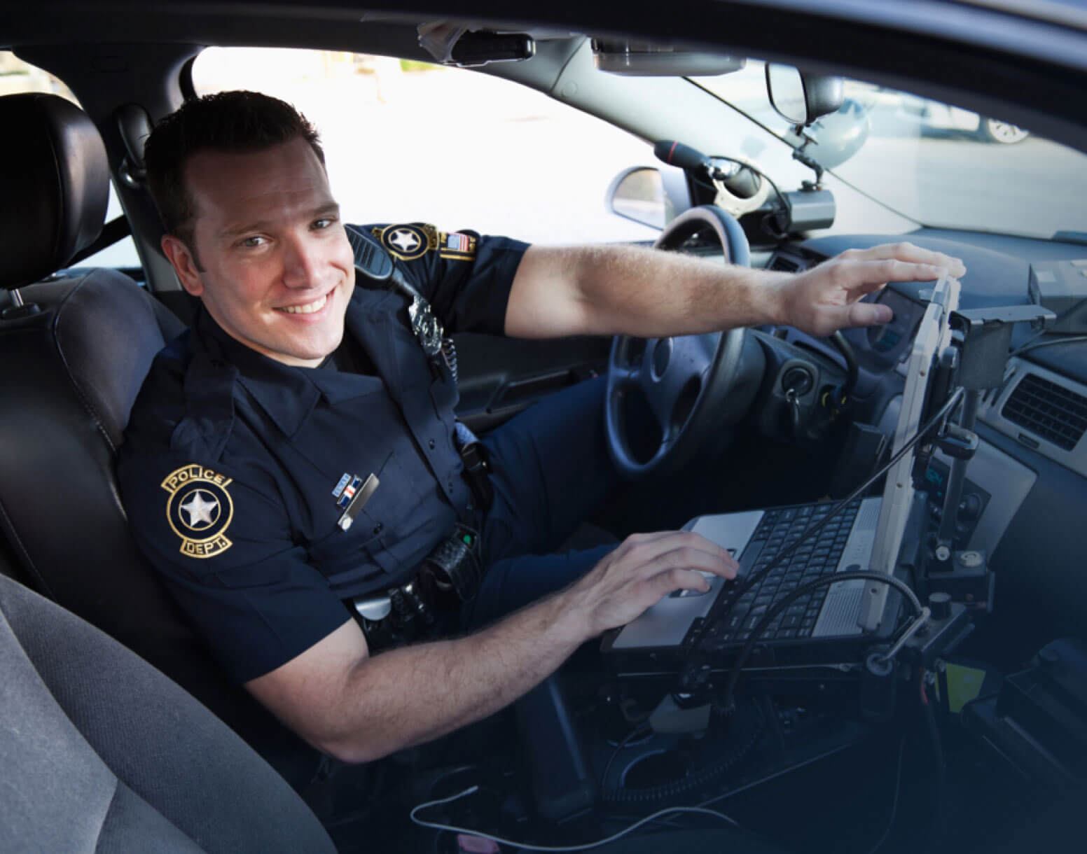 Police officer sitting in his cruiser.